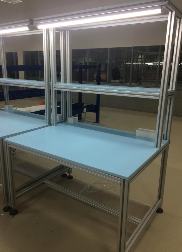 Assembly table is supplied using aluminium profiles extrusion and particle board top. This aluminium table is custom design at low cost using Rexroth T-slot aluminium profiles.