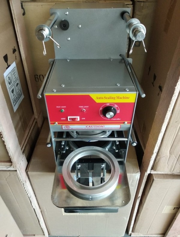 we are the leading supplier Dealer and manufacturer of automatic container sealing machine 123mm dia. this automatic container sealing machine is suitable for sealing 123 mm dia container for gulab jamun packing ,rasgulla packing ,sweet packing in 123mm dia container .in this machine we have to put the container in the tray for sealing and insert the tray in the machine after that up die automatically comes and seal the container and goes up after sealing after that we have to put out the tray and insert the another container for sealing after sealing roll automatically rewind and auto stop on sensor .this machine mostly used in bakery shops,foods industry for sweets packaging , gulab jamun packaging , rasgulla packaging in container AUTOMATIC CONTAINER SEALING MACHINE ,CONTAINER SEALING MACHINE ,CONTAINER SEALER MACHINE,BOWL SEALER MACHINE ,123 MM CONTAINER SEALER MACHINE ,123 mm container sealing machine,