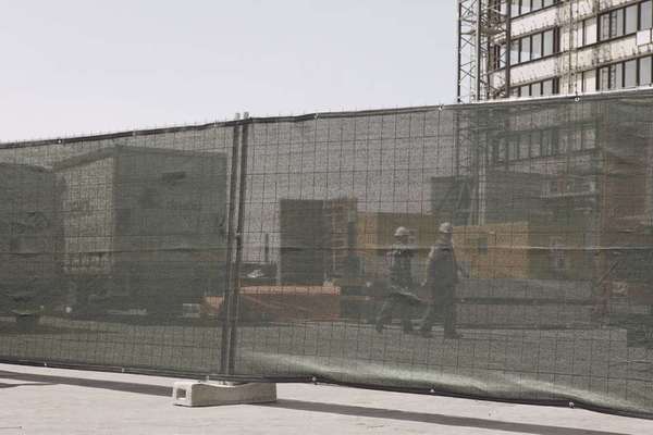 ACTING AS FENCING, PARTITION, SCAFFOLDING, AND BARRIER AT INDUSTRIAL, COMMERCIAL AND CONSTRUCTION SITES