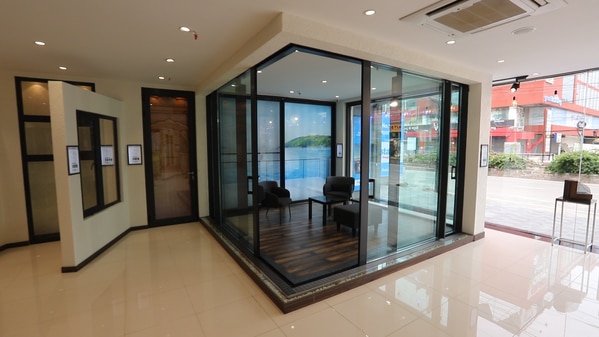 Fenesta’s Aluminum corner slider door is a slim line and 90 degree slider door concept that can effortlessly transform the corner areas. These are the most chosen ones where entry to gardens and balconies is desired and that too with a sense of flamboyance. Available with a thermal break system, Fenesta’s Aluminum corner sliding doors offer maximum natural light and side view from every side and comes with concealed frames and sashes.Corner slider doors are among the most premium door designs that add purpose to corner areas at home. The corner slider doors in aluminum that we manufacture here at Fenesta adhere to the highest quality standards. These doors are manufactured to precision by exceptionally skilled experts and are custom-made based on the exact dimensions of every corner space.It is with good reason why Fenesta is acclaimed as a pioneer in the manufacturing of completely customised aluminum doors. From design and the workmanship to the quality of fitting and the price - expect nothing but the best when you go for aluminum corner slider doors by Fenesta.FEATURES & BENEFITSThese doors have a thermal break system.These aluminum corner slider doors are available in a range of colours - diamond grey, walnut, light oak, champagne gold, and pristine white.The door can span 4 meters high and technically has a capacity of 500 kg per sash.These doors are built to last and require less maintenance.Fenesta aluminum corner slider doors have a one-of-its-kind drainage system. The drainage system of the sliding can be integrated with the drainage system of the building.These doors can have a configuration of 2 panels and 4 panels on one of the sides.These doors are highly energy-efficient and minimise thermal losses.The high acoustic insulation of these doors helps keep the dust, noise and pollution at bay.