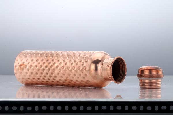 A copper water bottle is a type of water bottle that is made of copper metal. It is believed to have several health benefits, including improving digestion, reducing inflammation, and boosting the immune system.Copper water bottles typically have a capacity of around 750 ml and are designed to be leak-proof and durable. They are often finished with an attractive hammered or smooth surface and may also feature an ergonomic shape and a leak-proof cap.One of the key advantages of using a copper water bottle is that copper is believed to have natural antimicrobial properties, which can help to kill bacteria and viruses that may be present in the water. This can help to make the water safer and more hygienic to drink.In addition to its health benefits, copper is also a durable and long-lasting material that is easy to clean and maintain. Copper water bottles should be washed regularly with warm water and soap to keep them clean and free from bacteria.Overall, a copper water bottle is a useful and attractive accessory that can provide several health benefits and help to keep you hydrated throughout the day. It is a durable and long-lasting investment that can provide years of use and enjoyment.