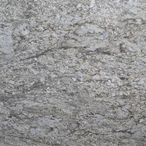 The earthy beauty of Blue Dunes Marble features a range of beige, grey, and black tones. This stone gets its name from tiny blue flecks that can be seen if you look attentively. Combining this neutral colour scheme with white cabinets, a stainless-steel backsplash, and appliances would look stunning.