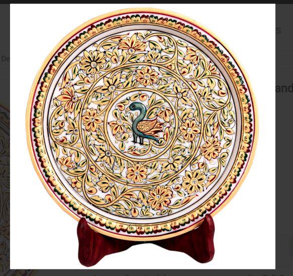 This decorative marble plate with gold handworkThe decorative marble plate with traditional Indian gold handwork can effortlessly translate the wall decor of any home interior from visually pleasing to aesthetically transcendental. The peacock pattern at the center of this decorative plate adds to its beauty, while the high quality marble provides the most pristine of backdrop to the exquisite design work.