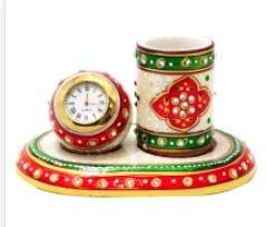 This Corporate Meenakari Pen Stand with Clock in marble is ideal for adding aesthetic appeal to any workstationThe Corporate Meenakari Pen Stand with Clock in Marble offers the perfect balance between aesthetic pleasure and practical usability. This pen stand, carved out of finest grade marble and featuring traditional Meenakari work, proves to be quite an eyeful for any workstation. However, it also contains a clock that makes it a handy best corporate gift for clients.