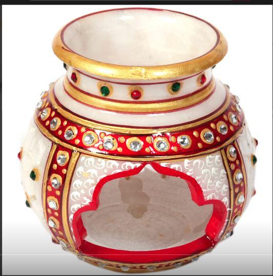 The decorative marble multicolor candle pot is ideal for lighting up a corner of the household during special occasions such as the Diwali, or during a power outage. The intricately carved opening at the bottom of this candle pot complements the ethnic design work present on its marble body. Moreover, the stone-studded patterns greatly accentuate its beauty along with the riot of lively colors to allure all its onlookers. This decorative candle pot is sure to find favor among all lovers of such items with great aesthetics and it will surely be an amazing anniversary return gift.