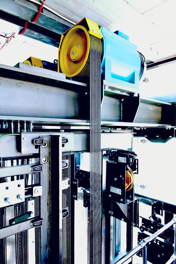 Machine-room-less elevators utilize a gearless traction machine located in the hoistway. The use of a counterweight assists the machine in turning the elevator sheave, which moves the cab through the hoistway