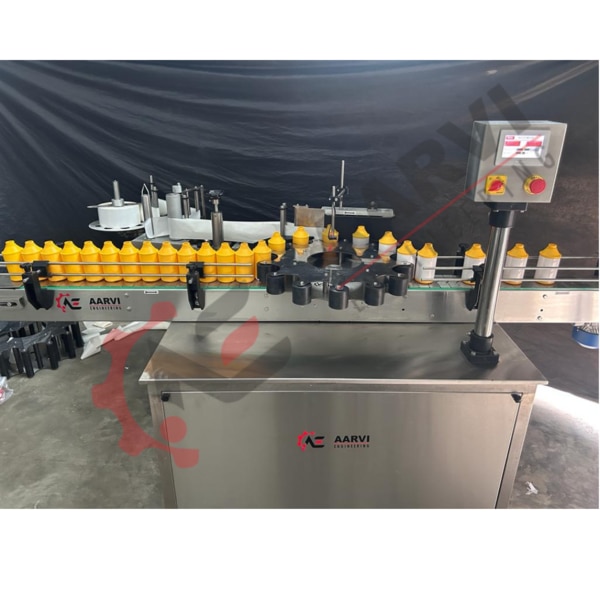 The Aarvi Engineering Automatic Rotary Self Adhesive Sticker labeling machine is typically installed in a line. Before Arriving the labeling station, containers are moved over a slat conveyor and divided by rollers. The Label is applied to the Container as soon as it is below the Container Sensor, assuring instantaneous edge adhesion. The pressing unit is used to precisely register and apply the crease-trees after it has gone through.A separate motor drives the machine's conveyor and pressing belt, which is controlled by a single A.C. motor controller device. In order to increase or reduce the device's speed. The labeling Device and its controller are driven by a different motor.Important Details:• positioning of labels precisely.• Unmatched construction quality and dependability• Additional pressure device.• A.C. frequency drive built-in• Due to the system's automatic label length recognition, label data inputs are not necessary.• One knob for controlling the speed.• imported gearbox and Bonvario motor.Technical Information:• Brand: Aarvi Engineering• Format of Labeling:Using a wraparound label• Beverage MOC:Glass/PET/HDPE• Bottle Form:Round form• Results / Minutes:Depending on the bottle size or label length, up to 40 to 100 bottles can be produced each minute.• An electric motor:Conveyor drive: 0.25 HP/1400 RPM• b) Pressing Device Drive, 0.25 HP/1400 RPM.• c) A 6 V DC motor.• Power:50 Hz at 230 volts AC.• Construction:S.S. 304 sheet is used to cover the top stainless steel structure and pipes in a mat Finish• Air Compressor:4–6 bars. (Only for printing apparatus)• Diameter of a label roll:Max. 400 mm.• Label precision:±1mm• All Dimensions Together:1950 mm long by 950 mm wide Adjustable 800 to 850 mm in height.