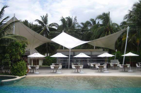 An auditorium tensile structure is a type of architectural design for auditoriums that incorporates tensile fabric materials for its roofing and sometimes even walls. Tensile structures are characterized by their use of tensioned elements, usually cables or membranes, to provide support and stability. These structures often have a striking, modern aesthetic and offer several advantagesVersatility: Tensile structures can be customized to fit various architectural designs and purposes, including auditoriums, stadiums, exhibition halls, and more.Natural Lighting: The translucent nature of tensile fabric allows natural light to filter through, creating a bright and inviting atmosphere within the auditorium during the day.Cost-Effectiveness: Tensile structures can be more cost-effective compared to traditional building materials like concrete and steel, both in terms of construction and maintenance.Quick Construction: These structures can be erected relatively quickly compared to traditional buildings, reducing construction time and associated costs.Durability: High-quality tensile fabrics are engineered to withstand harsh weather conditions, making them durable and long-lasting.Aesthetic Appeal: The sleek and modern design of tensile structures often adds aesthetic value to the surrounding environment, making them popular choices for contemporary architectural projects.Sustainability: Tensile structures can be designed with sustainability in mind, utilizing recyclable materials and incorporating features such as rainwater harvesting and solar panels.