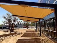 A porch area tensile shade is a type of shading structure typically used to cover outdoor spaces like porches, patios, or decks. It consists of a fabric canopy stretched over a framework of tensioned cables or poles. These shades provide protection from the sun's rays, reducing heat and glare while still allowing some light to filter through. Tensile shades come in various shapes, sizes, and designs, offering both functional benefits and aesthetic appeal to outdoor areas. They can be customized to fit specific spaces and are often chosen for their durability and weather resistance.