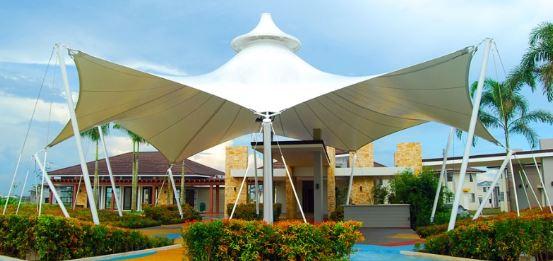 Tensile structure roofing is an innovative and versatile solution for resort architecture, offering both aesthetic appeal and functional benefits. Here’s an overview of key aspects of tensile structure roofing for resorts:AdvantagesAesthetic Appeal:Unique Designs: Tensile structures allow for creative and eye-catching designs, contributing to the resort's visual identity.Transparency: Materials like ETFE (Ethylene Tetrafluoroethylene) offer transparency, allowing natural light to filter through while providing protection from the elements.Durability and Strength:High Tensile Strength: Materials used in these structures, such as PVC-coated polyester fabric or PTFE (Polytetrafluoroethylene)-coated fiberglass, have high tensile strength, making them durable and resistant to extreme weather conditions.UV Resistance: These materials often come with UV resistance, prolonging their lifespan and maintaining their appearance over time.Flexibility and Adaptability:Large Spans: Tensile structures can cover large areas without internal supports, providing unobstructed spaces which are ideal for outdoor areas like pools, event spaces, and dining areas.Modular Design: They can be designed as modular units, making them adaptable for various uses and allowing for future expansion or reconfiguration.Environmental Benefits:Sustainability: Many tensile materials are recyclable, and their lightweight nature reduces the amount of supporting structure needed, which can decrease the overall carbon footprint.Energy Efficiency: By allowing natural light to penetrate, tensile roofs can reduce the need for artificial lighting during the day, thus saving energy.Cost-Effectiveness:Reduced Construction Time: The prefabricated nature of tensile structures allows for quicker installation compared to traditional roofing methods, reducing labor costs and downtime.Lower Maintenance: These structures generally require less maintenance, as the materials are resistant to mold, mildew, and dirt accumulation.Design ConsiderationsMaterial Selection:PTFE-Coated Fiberglass: Ideal for permanent structures due to its durability and resistance to environmental factors.PVC-Coated Polyester: More cost-effective and suitable for temporary or semi-permanent installations.Structural Design:Load Calculations: Proper load analysis is crucial to ensure the structure can withstand local weather conditions, including wind, snow, and seismic activity.Anchoring Systems: Depending on the location and soil conditions, various anchoring methods like ground anchors, concrete footings, or wall-mounted supports are used.Climate Considerations:Temperature Regulation: The design can incorporate features like ventilation openings or reflective coatings to manage heat buildup.Rainwater Management: Integrated drainage systems ensure effective water runoff to prevent pooling and potential damage.Architectural Integration:Harmonizing with Surroundings: The design should complement the resort’s overall aesthetic and natural surroundings.Functional Zones: Defining clear functional zones within the resort can help determine the best application of tensile structures, whether for shading, shelter, or purely decorative purposes.Applications in ResortsOutdoor Dining Areas: Providing shaded, weather-protected spaces that enhance the dining experience.Poolside Covers: Offering protection from the sun while maintaining an open, airy feel.Event Spaces: Creating flexible, attractive venues for weddings, parties, and other events.Walkways and Entrances: Adding visual appeal and practical cover for pathways and entrances.Case StudiesThe Burj Al Arab Terrace (Dubai):This iconic luxury hotel uses tensile structures for its pool and lounge areas, blending modern design with functional shading.Marina Bay Sands (Singapore):Features tensile roofing in its outdoor areas, providing both aesthetic value and practical shelter for guests.Tensile structure roofing offers a combination of aesthetic elegance, functional versatility, and environmental benefits, making it an ideal choice for modern resort designs.