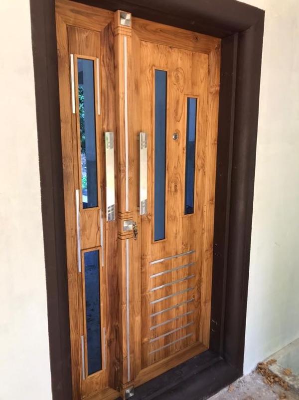 This Design Combines the Natural Beauty of Nilambur Teak with Modern Elements Like Glass Inserts and Brass Hardware. the Result Is a Sophisticated and Functional Main Door That Complements Modern Homes. Solid Nilambur Teak Wood for the Door Frame and Panels.Tempered Glass Inserts for a Modern Touch. Small See-Through Glass Portions (E.g., Geometric Shapes Like Circles, Rectangles, or Triangles).Frosted or Clear Glass for Privacy and Elegance.Optional: Stained Glass for a Pop of Color. Sleek, Modern Brass Handles with a Polished or Antique Finish.Matching Brass Hinges and Locks for a Cohesive Look.Door Style:Flat Panel Design with Clean Lines for a Minimalist Aesthetic.Optional: Subtle Wood Carvings or Grooves for Texture.Finish:Natural Teak Finish to Highlight the Wood's Grain.Matte or Polished Finish for a Refined Look.Dimensions:Standard Size: 7 Feet (Height) X 4 Feet (Width).Customizable to Fit Your Entrance.