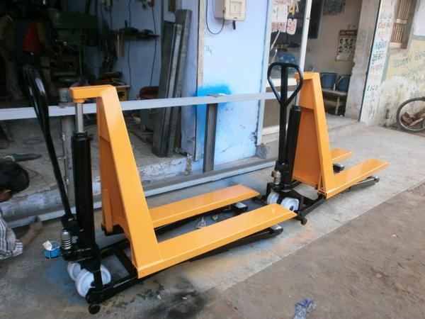 Hydraulic Hand Pallet Trolley Manufacturers in AhmedabadWe are also supply in Andhra Pradesh, Arunachal Pradesh, Assam, Bihar, Chhattisgarh, Goa, Gujarat, Haryana, Himachal Pradesh, Jharkhand, Karnataka, Kerala, Madhya Pradesh, Maharashtra, Manipur, Meghalaya, Mizoram, Nagaland, Odisha, Punjab, Rajasthan, Sikkim, Tamil Nadu, Telangana, Tripura, Uttar Pradesh, Uttarakhand, and West Bengal1. General SpecificationsType: Manual Hydraulic Pallet TruckOperation Mode: Hand-OperatedUsage: Lifting & Moving Pallets, Material Handling2. Load CapacityLoad Capacity: 1000 kg to 5000 kg (1 Ton - 5 Tons)Fork Length: 900 mm to 1500 mmFork Width (Overall): 520 mm to 685 mmFork Width (Individual): 160 mm to 180 mmLoad Center: 600 mm3. Lifting MechanismLift Height (Lowered Position): 85 mm - 100 mmLift Height (Raised Position): 200 mm - 250 mmPump Type: Heavy-Duty Hydraulic PumpPump Operation: Hand Lever / Foot Pedal4. Wheel & ChassisWheel Type: Nylon / Polyurethane / Rubber / Cast IronFront Wheel Size: 180 mm x 50 mm (Approx.)Rear Wheel Size: 80 mm x 70 mm (Approx.)Steering Angle: 180° - 210°5. Material & ConstructionFrame Material: Heavy-Duty SteelFinish: Powder Coated / GalvanizedReinforcement: Double Frame for Heavy Loads6. Safety & FeaturesErgonomic Handle with 3-Way Lever (Lift / Lower / Neutral)Overload Protection ValveSmooth & Silent MovementCorrosion-Resistant CoatingMaintenance-Free Hydraulic Unit7. Optional FeaturesLow Profile Model (For Special Applications)Stainless Steel / Galvanized Model (For Food & Pharma Industry)Scale Pallet Truck (With Digital Weighing Scale)Extra Wide or Narrow Forks