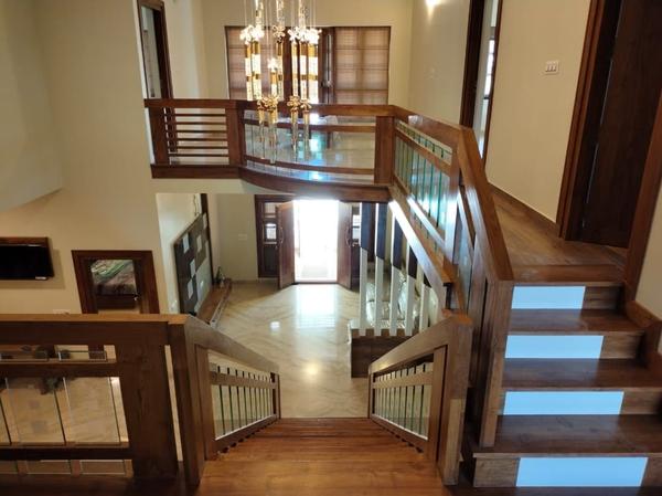 Today Information = The Teak Museum in Nilambur, established in 1995, is a popular tourist attraction. It showcases the history of cultivation.A Leading Teak Wood Interiors We Provide Affordable Cost And No Compromise in Quality In Works,Original Nilambur Teak Wood Only For All.A full teak wood interior in a staircase can create a luxurious, warm, and timeless aesthetic. Teak wood is highly valued for its durability, natural resistance to moisture, and beautiful grain patterns, making it an excellent choice for staircases.Teak Wood Treads and Risers: Use teak wood for both the treads (horizontal steps) and risers (vertical sections). This creates a cohesive and elegant look.Teak Handrails and Balusters: Pair the staircase with teak handrails and balusters for a seamless design. The handrails can be polished to a smooth finish for comfort and aesthetics: For a modern look, consider floating teak steps with hidden supports. This design highlights the beauty of the wood while creating a sleek, minimalist appearance.Teak and Glass Combination: Combine teak wood steps with glass balusters or railings for a contemporary and open feel.Teak and Metal Fusion: Use metal (e.g., stainless steel or black iron) for the structural framework and pair it with teak wood treads for an industrial yet warm aesthetic.Curved Teak Staircase: If your staircase has a curved design, teak wood can be crafted to fit the curves, showcasing its versatility and craftsmanship.Finishes for Teak WoodNatural Finish: Teak wood has a rich, golden-brown color that looks stunning with a clear sealant or oil finish. This enhances its natural beauty and grain.Matte or Satin Finish: A matte or satin finish provides a subtle sheen while maintaining a natural look.Stained Finish: If you prefer a darker or lighter tone, teak can be stained to match your interior design theme.Polished Finish: A high-gloss polish can give the staircase a luxurious and refined appearance.Benefits of Teak Wood in StaircasesDurability: Teak is one of the most durable hardwoods, making it ideal for high-traffic areas like staircases.Moisture Resistance: Its natural oils make it resistant to moisture, warping, and rot, which is especially useful in humid climates.Aesthetic Appeal: Teak wood has a rich, warm tone and unique grain patterns that add elegance to any space.Low Maintenance: Teak requires minimal maintenance, especially when left with a natural finish.Maintenance TipsRegularly clean the teak wood with a soft cloth and mild soap to remove dust and dirt.Apply teak oil or sealant periodically to maintain its luster and protect it from wear.Avoid using harsh chemicals or abrasive cleaners that can damage the wood.A full teak wood interior in a staircase is a statement of luxury and sophistication. Whether you prefer a traditional, modern, or transitional style, teak wood can be tailored to suit your design vision while offering unmatched durability and beauty.