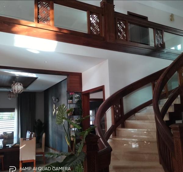 A Leading Teak Wood Interiors We Provide Affordable Cost And No Compromise in Quality In Works,Original Nilambur Teak Wood Only For All.Design and PlanningMeasurements: Take precise measurements of the staircase area, including the total rise (vertical height) and total run (horizontal length).Stringer Design: Determine the number of stringers required (typically 2-3 for a standard staircase). Calculate the rise and run for each step.Staircase Style: Decide on the style (e.g., straight, L-shaped, U-shaped, or spiral) and whether you want open or closed risers.Building Codes: Ensure the design complies with local building codes for safety and structural integrity. Material SelectionTeak Wood: Choose high-quality teak wood for its durability, resistance to moisture, and aesthetic appeal. Teak is ideal for staircases due to its strength and natural oils that protect against rot and insects.Stringers: Use thick teak planks (typically 1.5–2 inches thick) for the stringers to ensure they can support the weight of the stairs and users.Treads and Risers: Select teak planks for treads (the horizontal part of the step) and risers (the vertical part, if applicable). Cutting the StringersTemplate Creation: Create a template for the stringer using plywood or cardboard. This ensures uniformity across all stringers.Marking: Use a framing square to mark the rise and run on the teak wood stringers.Cutting: Carefully cut the stringers using a circular saw or jigsaw. Finish the cuts with a handsaw for precision.Notching: Cut notches for the treads and risers if you’re using a housed stringer design. Assembling the StaircasePositioning Stringers: Secure the stringers in place using temporary supports. Ensure they are level and properly spaced.Attaching Treads and Risers: Fix the teak treads and risers to the stringers using wood screws or dowels. Pre-drill holes to prevent splitting.Reinforcement: Add additional support blocks or brackets if necessary for stability. FinishingSanding: Sand the entire staircase with progressively finer grit sandpaper (start with 80-grit and finish with 220-grit) to achieve a smooth surface.Sealing: Apply a teak sealer or oil to protect the wood and enhance its natural color. Avoid using polyurethane, as it can create a slippery surface.Polishing: Buff the staircase to a smooth finish for a luxurious look.MaintenanceRegular Cleaning: Wipe the staircase with a damp cloth to remove dust and dirt.Re-oiling: Reapply teak oil or sealer every 6–12 months to maintain the wood’s appearance and durability.Inspection: Periodically check for loose treads or stringers and tighten screws or bolts as needed.