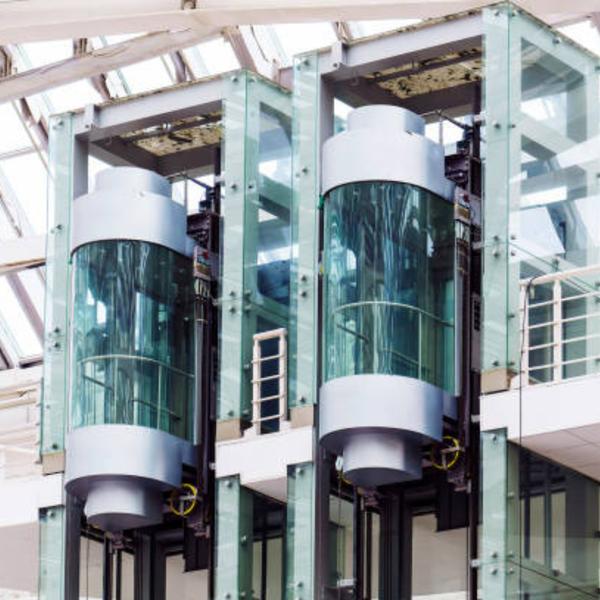 The Vini Capsule Elevator is a futuristic and stylish vertical mobility solution designed for hotels, shopping malls, corporate buildings, and luxury residences. Featuring a sleek, glass-enclosed cabin with panoramic views, this elevator enhances the architectural beauty of any space while delivering a smooth, silent, and comfortable ride.Key Features: - Futuristic Capsule-Shaped Design – Adds a modern and luxurious appeal to buildings - 360° Glass Panel Views – Panoramic visibility enhances aesthetics and ambiance - Smooth & Silent Performance – Gearless traction technology ensures vibration-free operation - Energy-Efficient Drive System – Reduces power consumption while ensuring optimal performance - Customizable Interiors – Choice of premium flooring, lighting, and ceiling designs - Smart Control System – Touchless buttons, AI-based traffic control, and IoT connectivity - Advanced Safety Features – Emergency stop, auto-rescue system, overload sensors, and fire-resistant materialsThe Capsule Elevator by Vini Elevators is an icon of elegance and innovation, making it an ideal choice for architectural landmarks, commercial hubs, and luxury establishments.