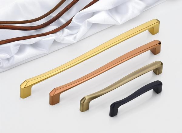 A sophisticated collection of handles, identified as DP-CH-010 Cabinet & Wardrobe Handles, presents minimalist elegance and diverse material expressions, ideally suited for enhancing wardrobe doors. Each handle features a subtly curved, elongated bar that offers a comfortable grip, seamlessly transitioning into clean, angular mounting bases at either end. The available finishes showcase a spectrum of modern aesthetics, including a radiant, polished brass, a warm and inviting bronze or copper tone, a sleek and understated matte black, and a refined silver or grey, with the potential application of a durable PVD finish on select variants for enhanced longevity and a touch of understated luxury.The design of these handles prioritizes clean lines and a smooth, uninterrupted flow, creating a sense of understated sophistication. The gentle curve of the central bar adds a touch of ergonomic comfort, while the sharp, geometric bases provide a contemporary anchor point. This harmonious blend of soft curves and crisp angles ensures that these handles complement a wide range of interior design styles, from minimalist to transitional.Crafted from high-quality, corrosion-resistant materials, these handles are engineered to withstand the demands of daily use without succumbing to wear or environmental degradation, ensuring their refined appearance persists over time. The potential inclusion of a PVD finish, particularly on the metallic variants, further enhances their durability, providing a robust protective layer against scratches, fading, and corrosion, making them a practical and stylish choice for diverse interior environments.The curated selection of finishes – brass finish, bronze/copper tone, matte finish, and silver/grey (potentially PVD finish) – facilitates versatile integration with a wide spectrum of design palettes. The polished brass offers a touch of classic warmth, the bronze/copper introduces a sense of richness and depth, the matte black provides a contemporary and understated elegance, while the silver/grey offers a sleek and modern sophistication. This range ensures seamless harmony with existing hardware and décor, allowing for a cohesive and stylish look throughout a space.Although the keywords 