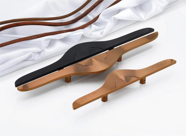 This unique set of door handles makes a dramatic design statement by fusing sculptural form with modern art-inspired aesthetics. The silhouette flows like a fluid ribbon, tapering gracefully at the ends and expanding organically in the center. It's a bold reinterpretation of the traditional handle—more a piece of architectural sculpture than mere hardware.What sets these handles apart is the mesmerizing layering of finely cut, wave-like grooves that seem to ripple outward from the core, creating a hypnotic sense of motion and depth. The interplay of negative space and curved precision gives the handle a tactile elegance, inviting both the eye and the hand to engage.The two-tone finish further enhances its visual intrigue: a warm, matte bronze tone serves as the foundation, while the upper surface—rendered in a stark, matte black in one version—adds contrast and bold sophistication. The monochrome variant keeps it subtle and refined, showcasing the contours without distraction.Striking yet functional, this handle design is an artistic centerpiece perfect for interiors that favor experimental design, expressive form, and high-impact details. It’s not just a handle—it’s a conversation starter.