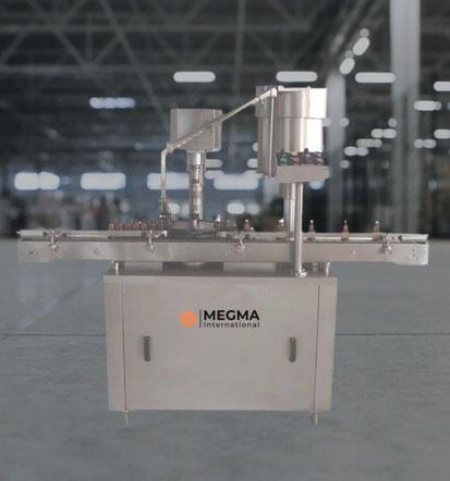 An Automatic Single Head ROPP/Screw Capping Machine by Megma International is a compact and efficient system designed for sealing bottles with ROPP or screw caps It ensures safe and impenetrable sealing and is widely used in the chemical, food and beverage, pharmaceutical, and cosmetic sectors. The machine is suitable for small to medium production volumes and can handle various container sizes with minimal changeover time.Bottles are transported to the capping station via a conveyor system, where a cap-feeding mechanism attaches the cap to the container to start the process. After that, a regulated torque is applied by the servo-driven or pneumatic capping head to firmly seal the cap. By creating threads on the aluminum cap, threading rollers for ROPP caps produce an ideal seal. Once sealed, the container is ready for additional processing, such labeling or packaging. Precision torque adjustment and seamless operation are made possible by the PLC and HMI that manage the entire system.