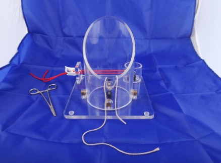 Maverick’s Knot tying trainer is a simulation tool designed to help medical students and trainees practice and perfect surgical knot tying techniques. The trainer has been crafted from a durable,light weight and transparent organic glass material for long-lasting use and optimal visualizationUnique magnetic system which replicates tissue tension.Parallel elastic knotter tube system which mimics blood vessels for vascular knotting practice.Transparent cylinders allow accurate assessment of knot tying competence.2 pre-operative openings:-(a) Small,shallow fixed cylinder for confined space practice.(b) Medium depth and diameter for vertical knot tying practice(c)Large ,deep and reversible cylinder for angled abdominal & gynecological depth tying.Easy to clean ,resistant to wera & tear,easily assemble ,Light weight & compact.