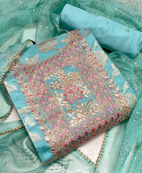 Brighten up your ethnic wardrobe with this refreshing and stylish Firozi Embroidered Dress Material with Jacquard Dupatta. Featuring intricate embroidery and a luxurious jacquard dupatta, this unstitched ensemble is the perfect fusion of rich craftsmanship and contemporary color. Whether it's for festive gatherings or elegant daywear, this set offers effortless charm and comfort.Top Material: Soft and breathable fabric in a vibrant Firozi (turquoise blue) shade, beautifully embellished with fine embroidery in floral or traditional patterns, adding a touch of elegance and sophistication.Bottom Material: Matching or contrasting cotton or blended fabric, providing ease and comfort for long wear while complementing the embroidered top.Dupatta: A rich, jacquard-woven dupatta in complementary hues, featuring elegant self-design or zari patterns that elevate the entire look with a regal touch.Key Features:Fabric: Soft Cotton/Poly Blend (Top & Bottom), Jacquard (Dupatta)Work: Fine Thread Embroidery on TopColor: Firozi Blue with Coordinated DupattaType: Unstitched — tailor it to your preferred style (A-line, straight, Anarkali)Occasion: Ideal for festive occasions, traditional events, and graceful daywearCare: Dry clean or gentle hand wash recommended for best resultsFabric Measurements:Top: Approx. 2.5 metersBottom: Approx. 2.5 metersDupatta: Approx. 2.25 meters
