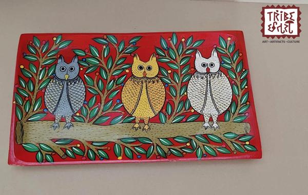 Wooden Hand Painted tray/PlatterThese hand-painted trays feature the vibrant and earthy Santhal painting style, a traditional tribal art form from the Santhal community of West Bengal.🎨 Art Style:Santhal paintings are known for their bold lines, rhythmic patterns, and vibrant storytelling.Common themes include tribal dances, music, nature, daily village life, and scenes of community bonding.The art reflects the joyous spirit and close connection to nature of the Santhal people.🖌️ Craftsmanship:Each tray is individually hand-painted by rural artisans. The figures are often depicted in motion dancing, playing instruments, or farming — giving the artwork a dynamic and lively character.🌿 Cultural Value:These trays  celebrate tribal heritage and indigenous identity, making them not just decorative items but also narratives of a living culture.Perfect for ethnic décor, gifting, or cultural collections.Available at Tribe Chatari, these trays a one-of-a-kind pieces that carry the spirit of rural India.