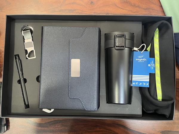 Corporate combo gift with sturdy box including T-shirt,Dairy,Bottle-or Tumbler , pen, Keychain, mobile stand, card holder. With customised branding in printing, laser engraving. 