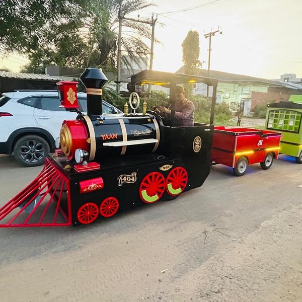 Bella Tori Train – A Joyful Ride That Steals Every CelebrationThe Bella Tori Train is a beautifully designed, road-ready mini train that adds charm, excitement, and unforgettable fun to any event. Inspired by a classic steam locomotive, this vibrant train features a powerful engine-style front, eye-catching colors, decorative wheels, and multiple passenger coaches designed for comfort and safety. Its attractive lighting and premium finish make it a standout attraction both during the day and at night.Perfect for weddings, birthday parties, fairs, exhibitions, resorts, malls, amusement parks, school events, and promotional activities, the Bella Tori Train offers a smooth and enjoyable ride for children as well as adults. The train is built with a strong metal and fiber body, ensuring durability, stability, and long-term performance even with regular use.Each coach is thoughtfully designed with proper seating, secure entry, and ample space, making it ideal for group rides. The driver-controlled system allows smooth handling, controlled speed, and safe operation on roads and event grounds. LED lights and decorative elements enhance its visual appeal, making it a crowd favorite and a perfect photo attraction.Whether you are looking to entertain guests, attract crowds, or add a premium experience to your venue, the Bella Tori Train is a reliable and profitable choice. It combines classic design, modern craftsmanship, and joyful entertainment in one unique ride.Create smiles, excitement, and memorable moments with the Bella Tori Train – where every ride feels like a celebration.
