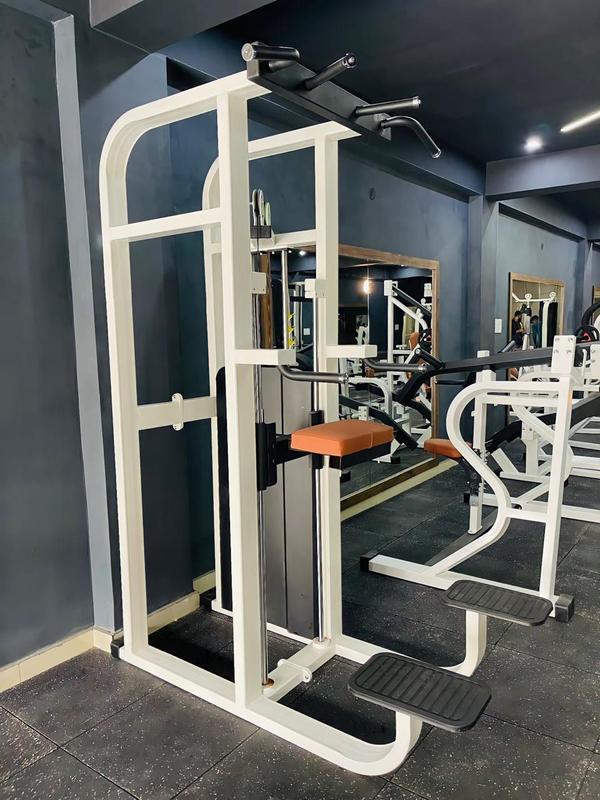 Functionality: The machine supports various exercise routines, primarily targeting the triceps, chest, shoulders, and back muscles through chin-ups, pull-ups, and dips. Assisted Mechanism: It is “assisted” because it uses a weight stack and a counterbalanced platform to help the user lift their body weight, making these challenging exercises accessible to a wider range of fitness levels, including beginners. Construction: The equipment features a heavy square steel frame with a powder-coated finish for durability and rust prevention. Design: The design includes multiple grip options for pull-ups and an adjustable bar for performing dips. It also features a padded support platform (with a brown/orange pad in the image) for comfort and elbow protection during use. Adjustability: The weight resistance can be easily adjusted using a pin-loading mechanism to accommodate the user's preference and strength level. 