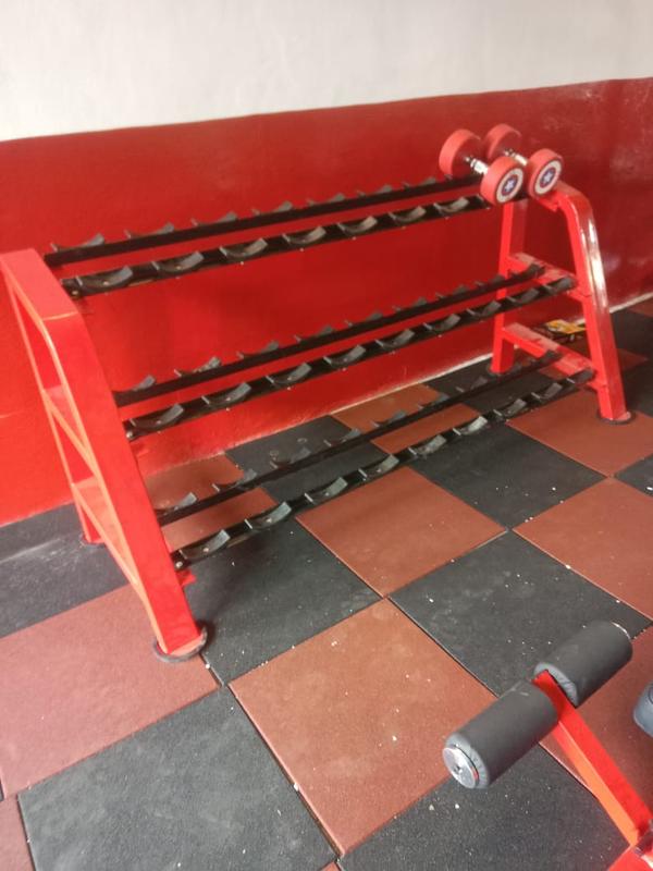 Material: The rack is generally constructed from heavy-duty materials like mild steel, ensuring durability and stability. Design: It features a space-efficient design with three tiers for systematic storage and easy access to multiple pairs of dumbbells. Color: The frame is powder-coated in a prominent red color, with the actual storage shelves in black. Capacity: Similar models are designed to hold a significant number of dumbbells, often up to 12 pairs or more depending on the specific dimensions. Usage: This type of equipment is intended for commercial or heavy-duty personal gym use. 