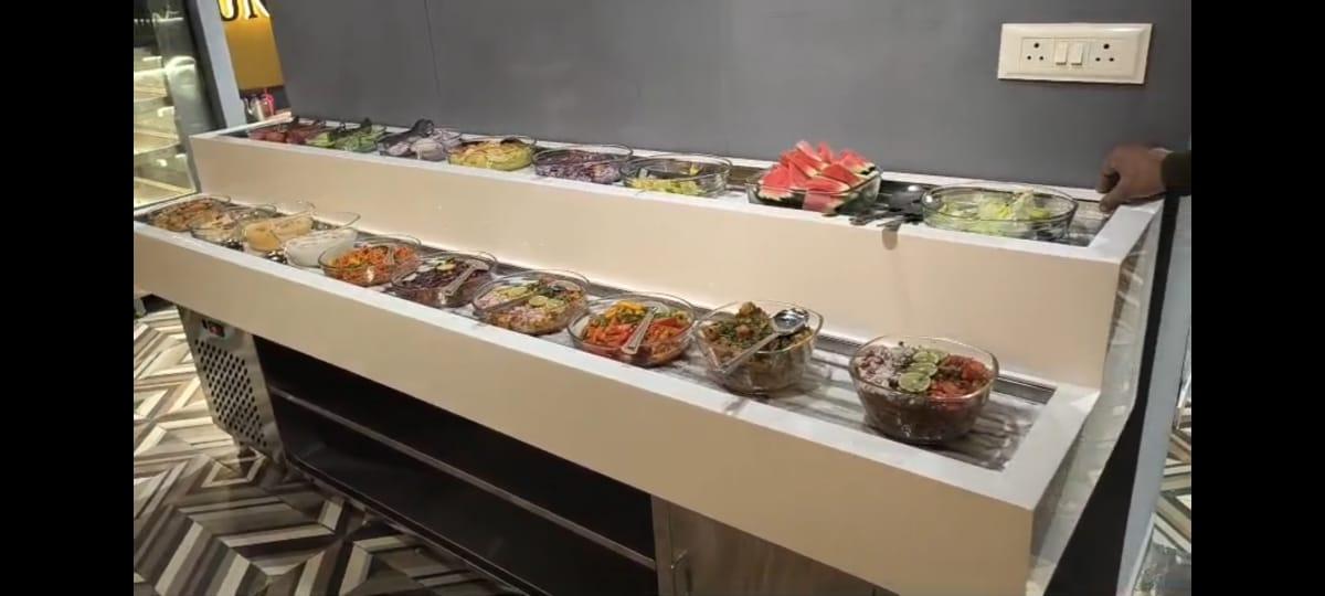 Salad Counter ManufacturersWe are also supply in Andhra Pradesh, Arunachal Pradesh, Assam, Bihar, Chhattisgarh, Goa, Gujarat, Haryana, Himachal Pradesh, Jharkhand, Karnataka, Kerala, Madhya Pradesh, Maharashtra, Manipur, Meghalaya, Mizoram, Nagaland, Odisha, Punjab, Rajasthan, Sikkim, Tamil Nadu, Telangana, Tripura, Uttar Pradesh, Uttarakhand, and West Bengal🔧 Refrigeration & CoolingTemperature Range: Typically +2°C to +8°C — ideal for salads and fresh produce.Cooling System:• Fan-assisted (forced air) for even, quick cooling.• Some models offer static cooling (no-fan) as an option.Refrigerant: Commonly R290 or R600a (eco-friendly, low GWP).Defrost Type: Automatic in most units for hygienic operation.📐 Construction & BuildExterior & Interior: Stainless Steel (SS304 or SS201) for hygiene and durability.Insulation: High-density polyurethane foam for thermal retention.Worktop: Heavy-duty stainless steel with cutting board space (if included). Typical for salad prep counters.Glass/Display: Clear tempered glass canopy (optional) for front-of-house display.📦 Capacity & LayoutGN Pan Compatibility: Usually accepts Gastronomy (GN) pans (e.g., 1/4, 1/3, 1/2, 1/1) — number depending on model width.Shelving/Compartments: Adjustable stainless wire shelves or GN pan rails.⚡ Electrical & PerformanceVoltage & Frequency: Typically 230V / 50 Hz (India standard).Power Consumption: ~150 – 400 W depending on size/capacity.Climate Class: Usually Class 4 (up to ~43 °C ambient).Noise Level: Commercial units often run < 50 dB(A).📊 Control & MonitoringDigital Temperature Controller & Display: For precise temp control.Safety Features:• High/low temperature alarm• Auto-defrost• Overload protection🧰 Additional Features (Optional)LED lighting inside for display.Castors for mobility.Magnetic gasket doors or glass sneeze guards.