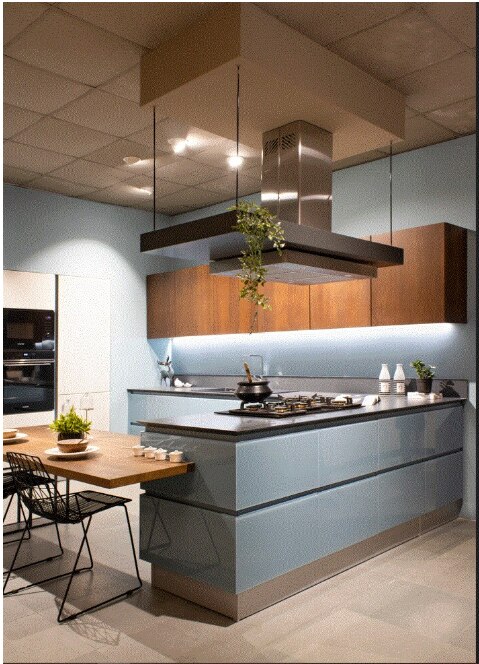 This elegant open kitchen depicts the modern time women who don't like to remain within  wall and at the same time she is connected with the living room.The stellar glass used in base shutter creates the freshness along with natural veneer on wall .the tall units in pastel PU enhances the overall premium looks