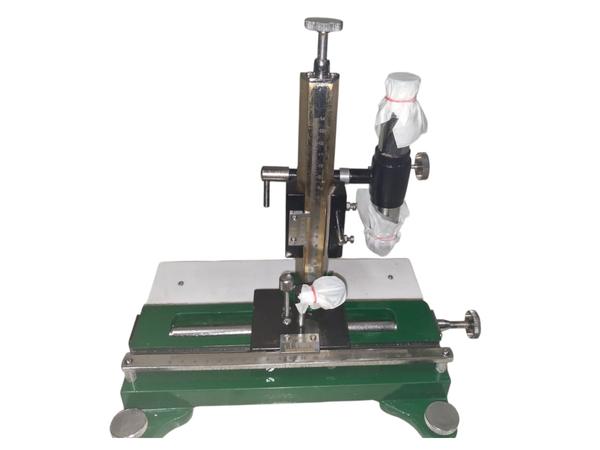 A travelling microscope consists of a microscope mounted on a movable carriage that travels along a graduated scale. The microscope can move horizontally and vertically using fine adjustment screws. This movement helps in accurately measuring the position of small objects or markings on a scale. The instrument provides highly precise readings, usually in millimeters or micrometers.