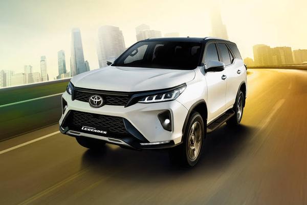 The Toyota Fortuner Legender is a premium, rugged 7-seater SUV distinguished by its aggressive catamaran-style front bumper, split quad-LED headlamps, and dual-tone roof. Available in 4x2 and 4x4 powertrain configurations, it is highly sought after for its powerful performance and luxury cabin appointments.Performance & SpecificationsThe Legender delivers robust power for both city streets and tough terrains:Engine: 2.8-liter (2755 cc) 4-cylinder turbo-diesel; also available with a 48V mild-hybrid setup for enhanced efficiency.Output: 204 PS (150 kW) maximum power.Torque: 500 Nm (Automatic), 420 Nm (Manual).Transmission: 6-speed Automatic with sequential shift, paddle shifters, and shift lock.Dimensions: 479.5 cm (L) × 185.5 cm (W) × 183.5 cm (H) with a 274.5 cm wheelbase.Fuel Capacity: 80 Liters.Key Features & DesignThe SUV is tailored for luxury and convenience, featuring a sleek, modern aesthetic:Exterior: 18-inch multi-layered machine-cut alloy wheels, front and rear sequential turn indicators, and a kick sensor for the power back door.Interior: Ventilated front seats, wireless smartphone charger, dual-zone climate control, and ambient illumination.Safety: Includes 7 airbags, Vehicle Stability Control (VSC) with Brake Assist (BA), Hill Assist Control (HAC), and front/rear stabilizer controls.Variants & PricingPricing for the Legender varies depending on the drive type and region:4x2 AT: Starts around ₹42.92 Lakh.Neo Drive (Mild-Hybrid): Goes up to ₹48.29 Lakh.4x4 (Diesel / Mild Hybrid): Ranges between ₹55.85 Lakh and ₹59.80 Lakh.
