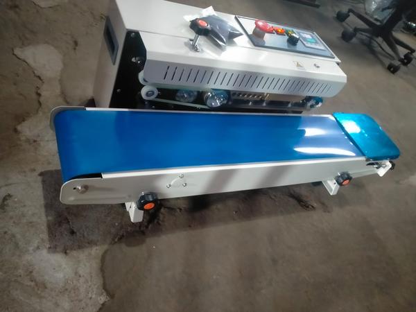 A Band Sealer Machine is a continuous sealing machine used for sealing plastic pouches, laminated bags, and packaging materials in industries such as food processing, pharmaceuticals, chemicals, agriculture, and consumer goods. It operates by moving filled bags through a pair of heated sealing belts that create a strong, airtight, and leak-proof seal.Key Features:Continuous and high-speed sealing operationAdjustable temperature and conveyor speedSuitable for various pouch materials (PP, PE, laminated films, aluminum foil laminates, etc.)Strong and uniform sealing qualityLow maintenance and user-friendly operationAvailable in horizontal and vertical modelsOptional batch coding or embossing systemApplications:Food products (snacks, spices, tea, coffee, grains)Pharmaceutical productsChemical powders and granulesAgricultural seeds and fertilizersCosmetic and personal care productsTechnical Benefits:Increases packaging efficiency and productivityEnsures product freshness and protectionReduces manual labor and sealing errorsSuitable for small, medium, and large-scale production units