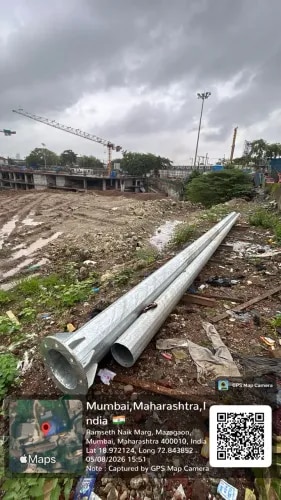 18 Meter High Mast Pole Manufacturing & Supply | Devine Developers, MumbaiHigh mast lighting systems are designed to provide powerful and wide-area illumination for large open spaces, infrastructure projects, commercial developments, roads, construction sites, and other demanding outdoor applications. For projects in Mumbai, the pole must combine structural strength, corrosion resistance, reliable performance, and long service life.For Devine Developers, Mumbai, AS INFRA ENGINEERS AND CONTRACTORS successfully manufactured and supplied an 18 Meter High Mast Pole, engineered as a heavy-duty lighting support structure for large-area illumination.1) What an 18 Meter High Mast Pole Really MeansAn 18 meter high mast pole is a tall, structurally engineered lighting support system designed to position multiple high-power LED floodlights or luminaires at a significant height.Unlike conventional street light poles, a high mast provides illumination over a much larger area from a single elevated point.The pole shown in this project features:Tall tapered polygonal structural profileHeavy-duty steel constructionLarge circular base plate for foundation connectionHigh-strength anchor bolt arrangementHot-dip galvanized finish for corrosion protectionDesign suitable for supporting high-power lighting equipmentStructural configuration intended for outdoor and demanding environmentsThe objective is to achieve maximum lighting coverage while maintaining structural stability and safe long-term operation.2) Why High Mast Poles Are Suitable for Mumbai ProjectsMumbai experiences heavy monsoon rainfall, high humidity, strong winds, and coastal environmental conditions. These factors can affect exposed steel structures if the material and protective coating are not properly selected.For high mast applications, corrosion protection is particularly important because the pole remains exposed to outdoor conditions throughout its service life.A properly manufactured high mast should therefore focus on:High-quality structural steelProper fabrication and weldingHot-dip galvanizationAdequate structural stabilityProper foundation and anchor-bolt connectionProtection against moisture and corrosionThe galvanized finish visible on the supplied pole provides an additional layer of protection against environmental exposure.3) Structural Strength and Wind Load ConsiderationsA high mast pole is continuously exposed to wind pressure because of its height and large exposed surface area.The structural design therefore needs to consider wind loading, pole geometry, wall thickness, foundation requirements, base plate dimensions, and anchor bolt arrangement.The high mast specifications used by AS INFRA are designed with consideration for relevant structural requirements, including IS 875 wind-load standards.For an 18 meter installation, the final structural design should be based on the actual project conditions, lighting load, location, and foundation design.4) Material and Fabrication QualityHigh mast poles require structural steel capable of handling the combined effects of pole self-weight, wind loading, and lighting equipment loads.The supplied high mast system is based on structural steel construction, with the specification reference using IS 2062 Grade / BS EN 10025 S355 structural steel for high mast applications.Important manufacturing considerations include:Accurate polygonal tapered fabricationProper plate forming and alignmentHigh-quality weldingAccurate base plate fabricationDimensional inspectionProper surface preparation before galvanizationQuality control throughout manufacturingThe specification also identifies Automatic Submerged Arc Welding (SAW) as the fabrication method for enhanced structural integrity.5) Hot-Dip Galvanized Finish for Long-Term ProtectionOne of the most important features of a high mast installed in Mumbai is corrosion protection.The high mast specification specifies Hot-Dip Galvanization (HDG) in accordance with IS 2629 / ISO 1461, with an indicative zinc coating range of 80–100 microns.Hot-dip galvanization helps protect the steel surface against:Rain and moistureHumidityAtmospheric corrosionCoastal environmental exposureLong-term outdoor weatheringProper galvanization is especially important around welded areas, edges, joints, and other exposed portions of the structure.6) High Mast Lighting System and MaintenanceHigh mast poles are commonly used with multiple high-power LED floodlights to illuminate large areas from a single elevated position.Depending on the project requirement, a high mast system can incorporate:Lantern carriage assemblyMultiple LED floodlightsMotorized raising and lowering mechanismStainless steel wire ropeWinch assemblyPulley systemSafety locking mechanismThese components allow lighting equipment to be brought down for maintenance instead of requiring extensive working-at-height arrangements.This makes high mast systems practical for locations where regular access to lighting equipment is required.7) Base Plate, Anchor Bolts and FoundationThe base of a high mast carries the structural load from the complete pole and lighting assembly into the foundation.The supplied pole has a heavy-duty circular base plate designed to connect the mast with the RCC foundation through anchor bolts.The overall foundation system should be designed according to:Pole heightWind loadSoil conditionsLighting equipment loadBase plate configurationAnchor bolt arrangementSite-specific structural requirementsA properly designed RCC foundation and accurately aligned anchor bolts are essential for maintaining the stability of the high mast throughout its service life.8) Applications of an 18 Meter High Mast PoleAn 18 meter high mast can be suitable for a wide range of outdoor lighting applications, depending on the project design and illumination requirements.Typical applications include:Residential and commercial developmentsConstruction and infrastructure sitesLarge parking areasRoads and internal access roadsSports groundsIndustrial premisesOpen public spacesPorts and large outdoor facilitiesLarge-area security and floodlighting applicationsThe high mast specifications also identify applications such as cricket stadiums, football grounds, hockey fields, sports complexes, athletic tracks, airports, ports, and other large outdoor venues.9) Quality Checks Before Dispatch and InstallationA high mast is a critical structural component, so quality inspection should be carried out before installation.Important checks include:Pole dimensions and overall heightBase plate dimensions and alignmentWeld qualityGalvanizing quality and coating thicknessStructural finishAnchor bolt compatibilityLighting equipment compatibilityRaising and lowering mechanism, where applicableOverall dimensional accuracyThe available high mast specification identifies factory testing for weld quality, galvanizing thickness, dimensional accuracy, structural strength, and raising/lowering mechanism.Final Takeaway: Strength, Protection and Reliable IlluminationThe 18 Meter High Mast Pole supplied to Devine Developers, Mumbai represents a combination of structural engineering, quality fabrication, corrosion protection, and practical high-level lighting application.For Mumbai projects, the most important factors are:Structural strength – designed considering applicable wind-load requirements.Corrosion protection – hot-dip galvanized steel for demanding outdoor conditions.Reliable lighting support – suitable for multiple high-power LED floodlights and large-area illumination.Safe maintenance – raising and lowering systems can simplify access to lighting equipment where incorporated into the project.Quality manufacturing – controlled fabrication, welding, dimensional accuracy, and galvanization.Manufactured & Supplied by AS INFRA ENGINEERS AND CONTRACTORSProject: 18 Meter High Mast PoleClient: Devine DevelopersLocation: Mumbai, Maharashtra