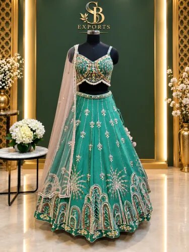 A stunning teal-green bridal/wedding lehenga set featuring an intricately embellished sleeveless blouse, a heavily detailed flared lehenga, and a delicate sheer dupatta. product image
